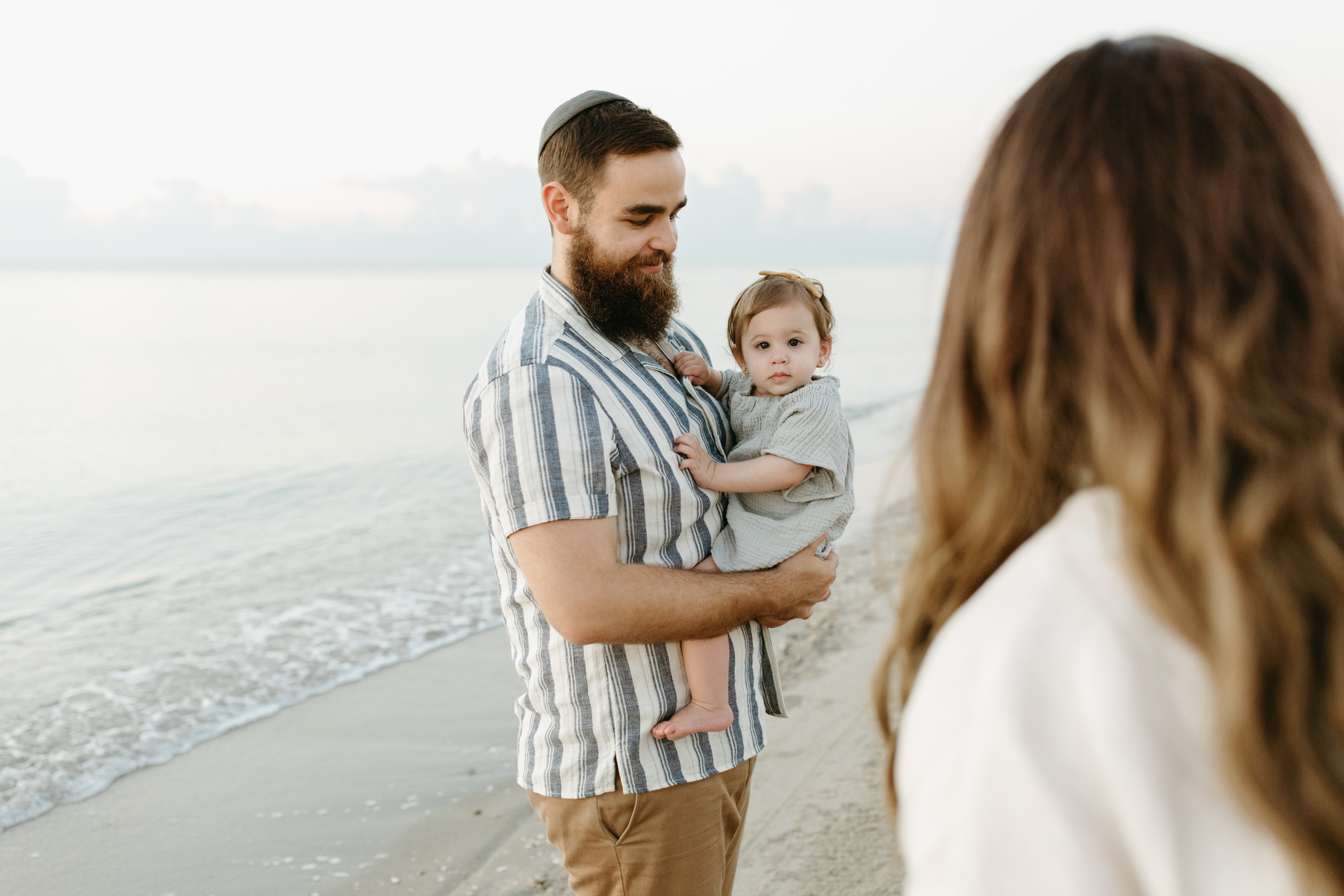 Family walks the beach at sunrise in Fort Lauderdale, Florida