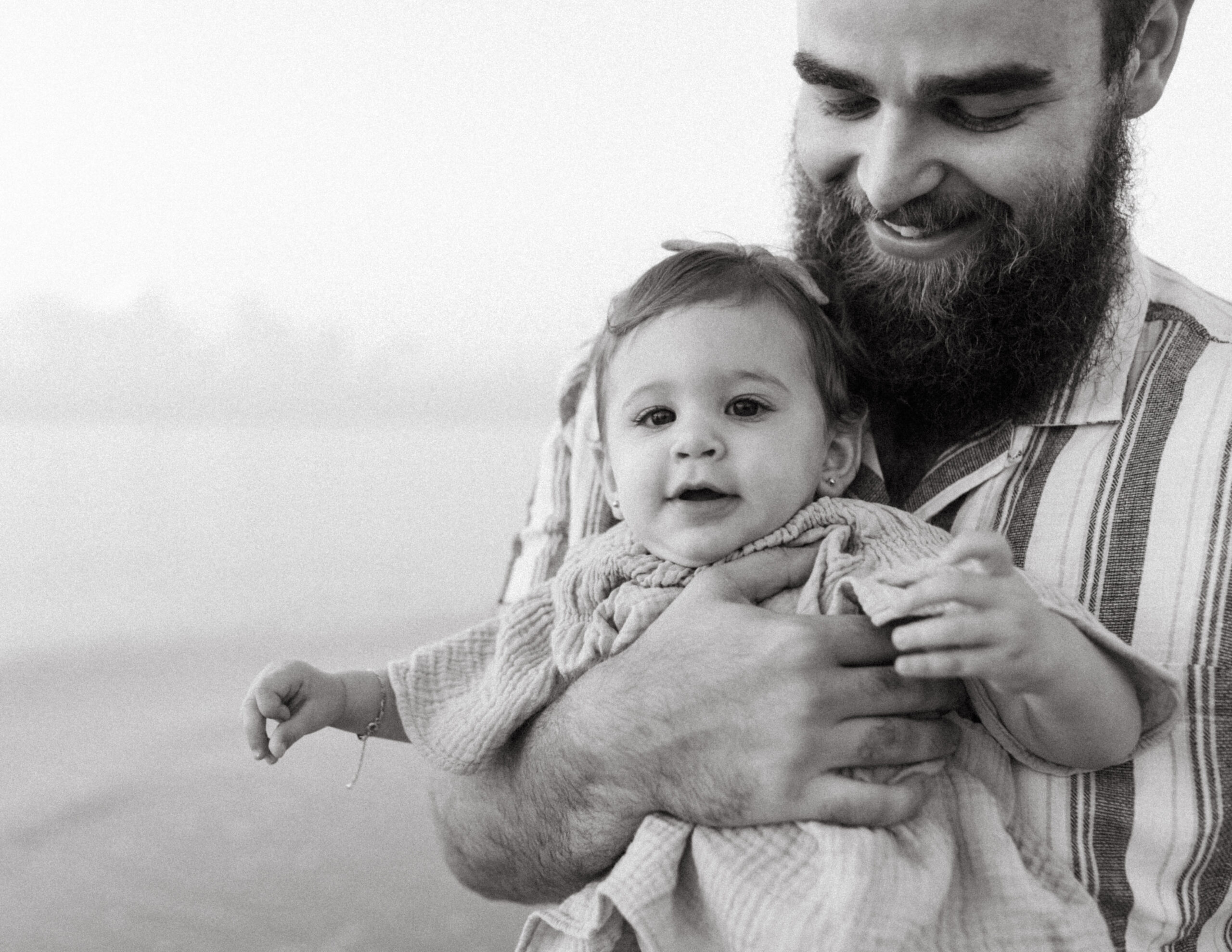 Family Photographer Lauren Neal Photography Father holds his daughter on the beach at sunrise in Fort Lauderdale, Florida