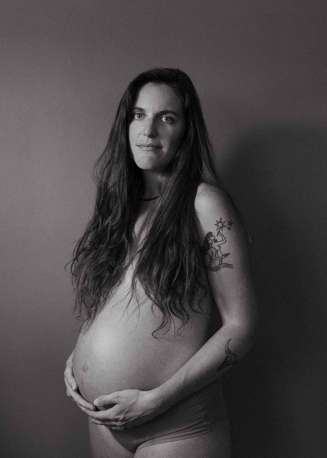 Jones Maternity Session Pregnant mother looks at herself in the bathroom in Cincinnati, Ohio