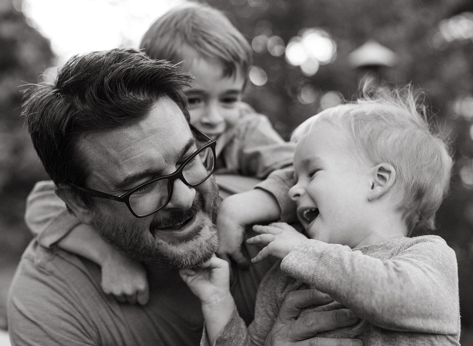 Two boys laugh and play with their father in Cincinnati, Ohio