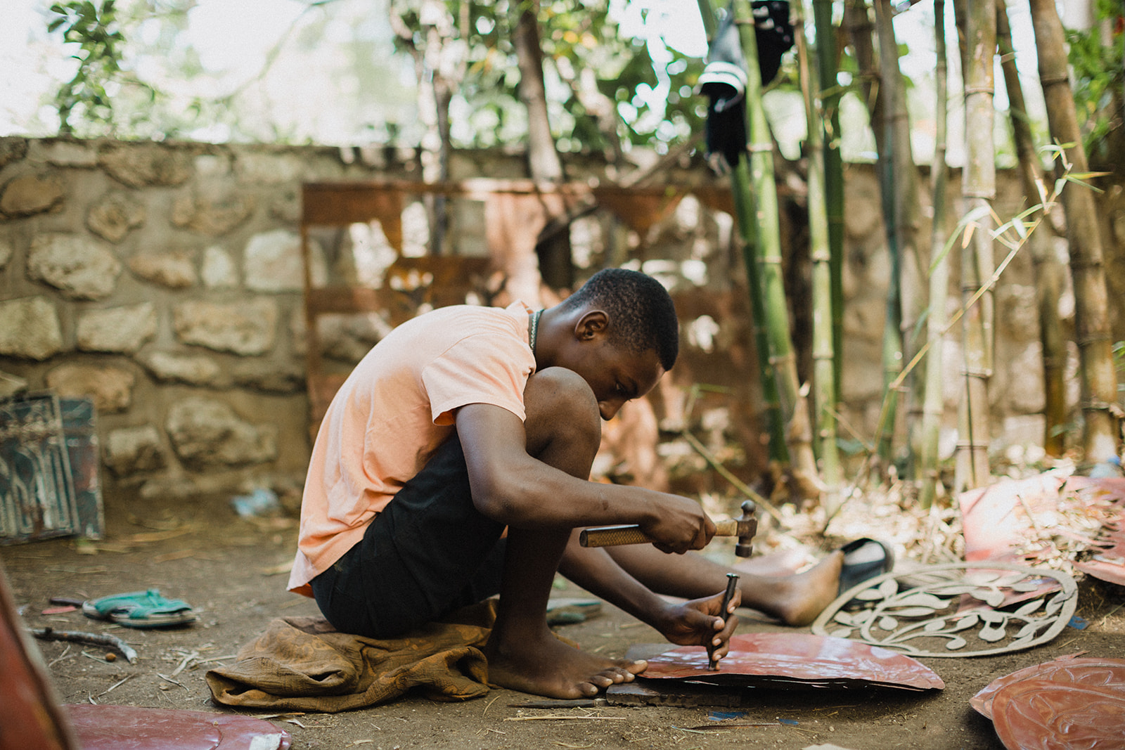 Haiti Humanitarian Photographer Lauren Neal Photography Haitian boys works on tin metal art in Port-au-Prince, Haiti