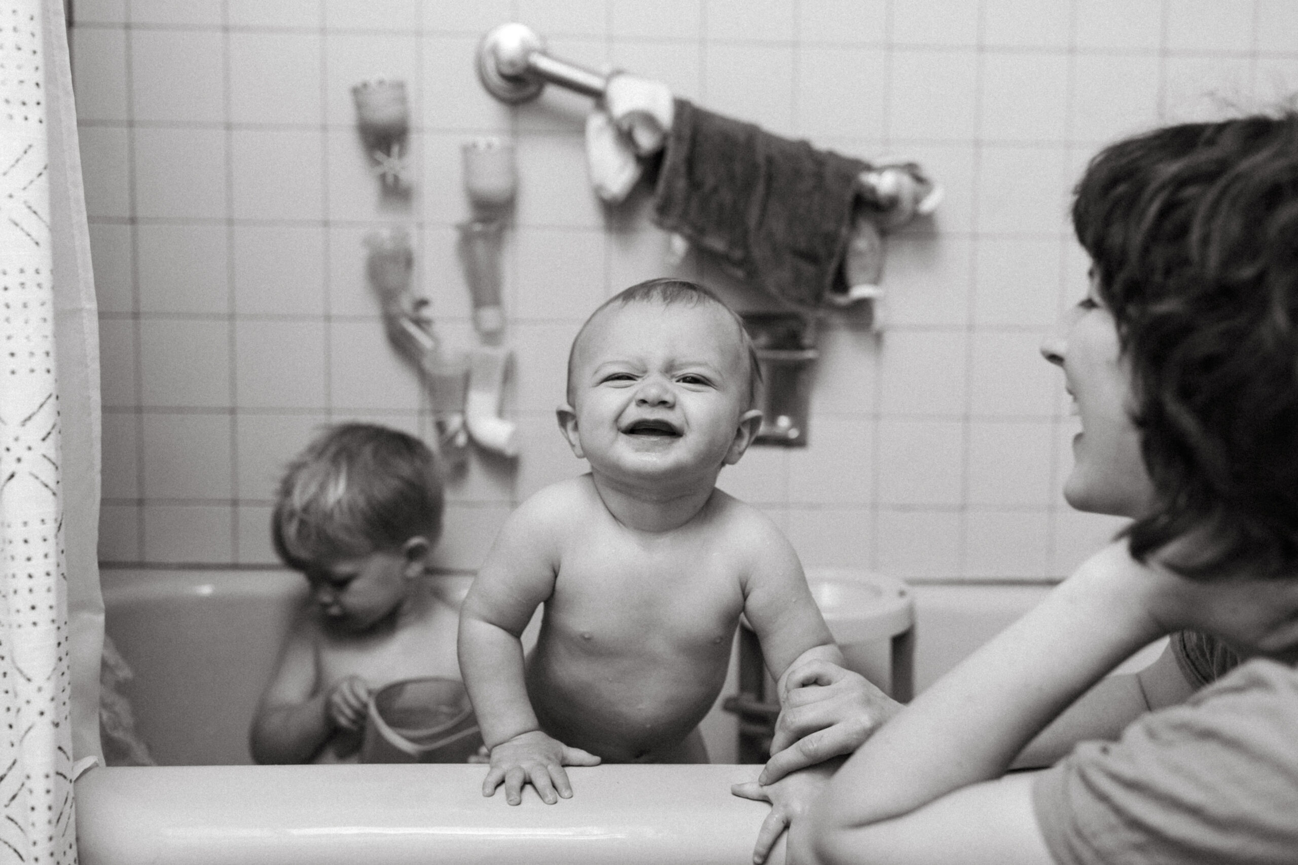 Two boys play in the bath while their mother watches in Cincinnati, Ohio