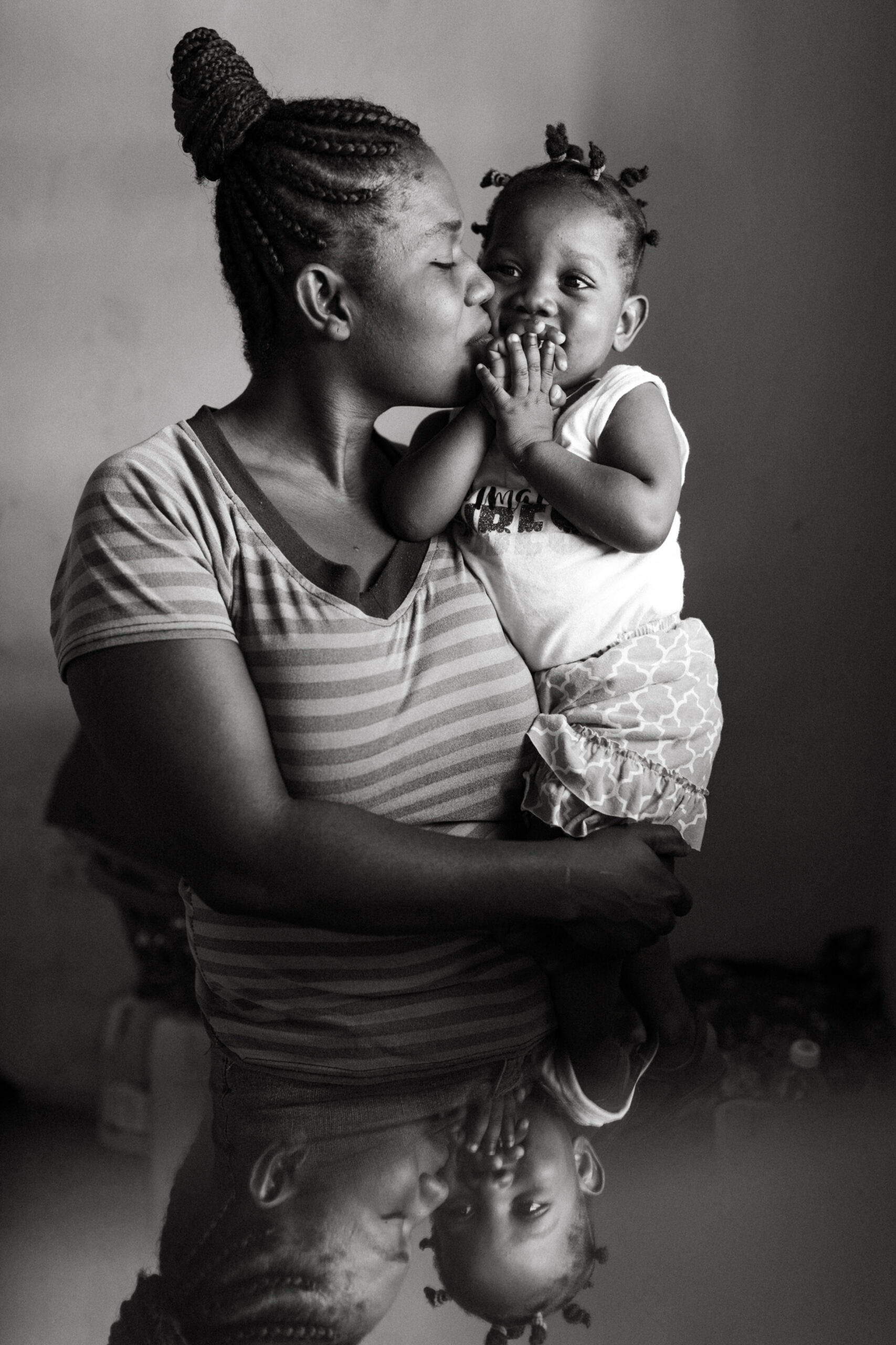 International Humanitarian Photographer Haitian woman holds her child in Port-au-Prince, Haiti