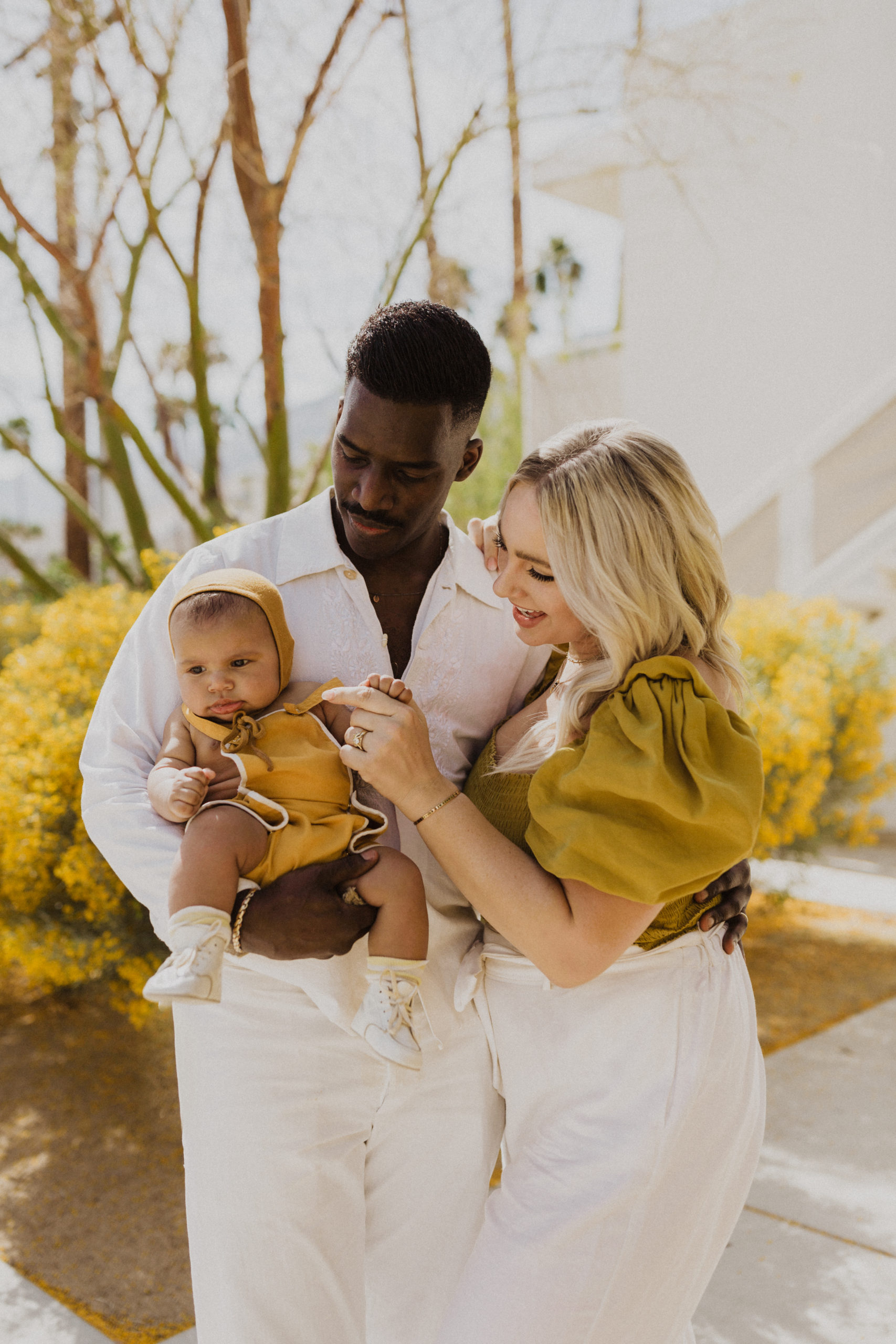 Mixed family in Palm Springs, California Lauren Neal Photography Mixed couple holds their baby at Ace Hotel in Palm Springs, California