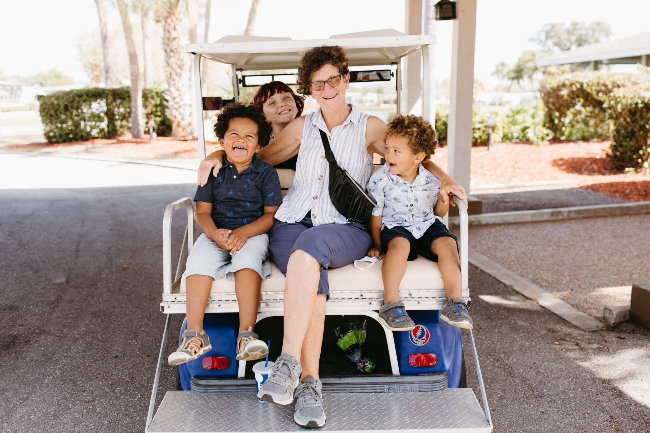 Grandmother rides with her three grandkids in a golf cart in Venice, Florida