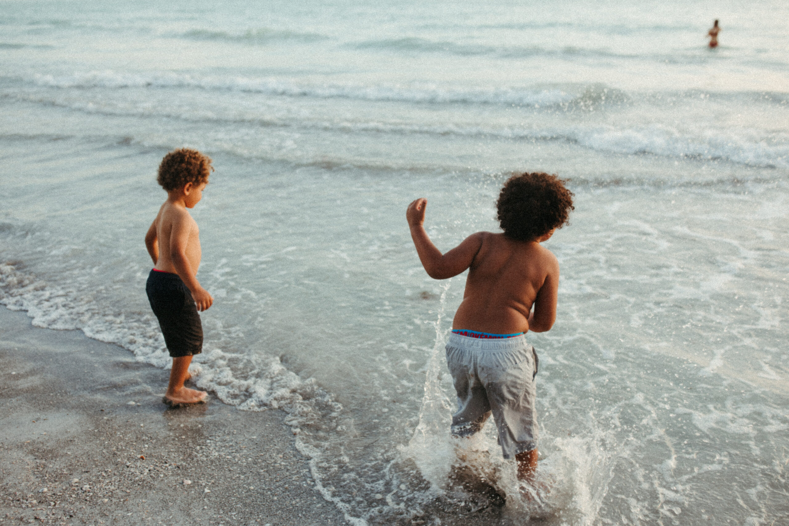 Two boys play in the ocean in Florida with their sister