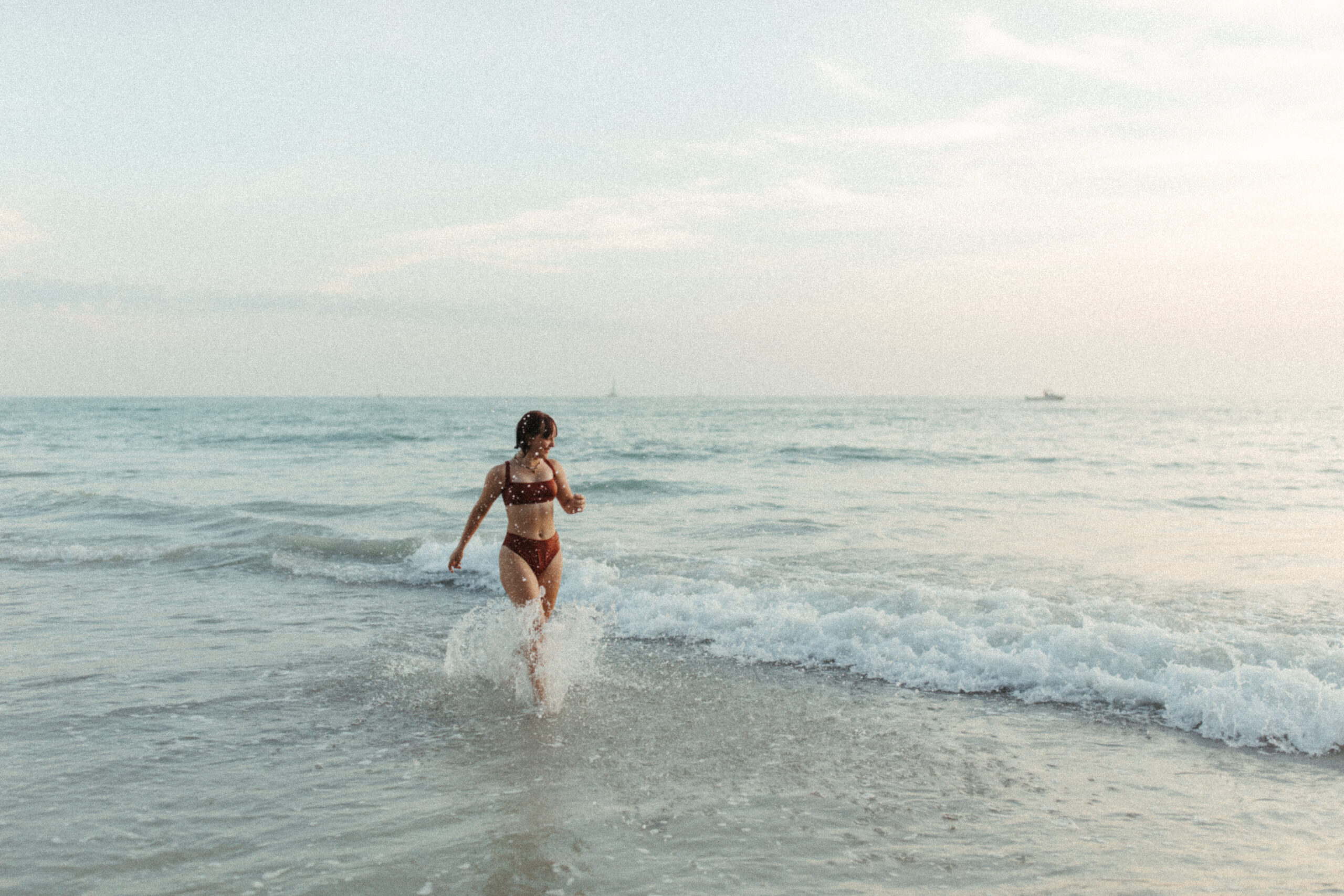 Teenage girl runs in the ocean in Venice Beach, Florida