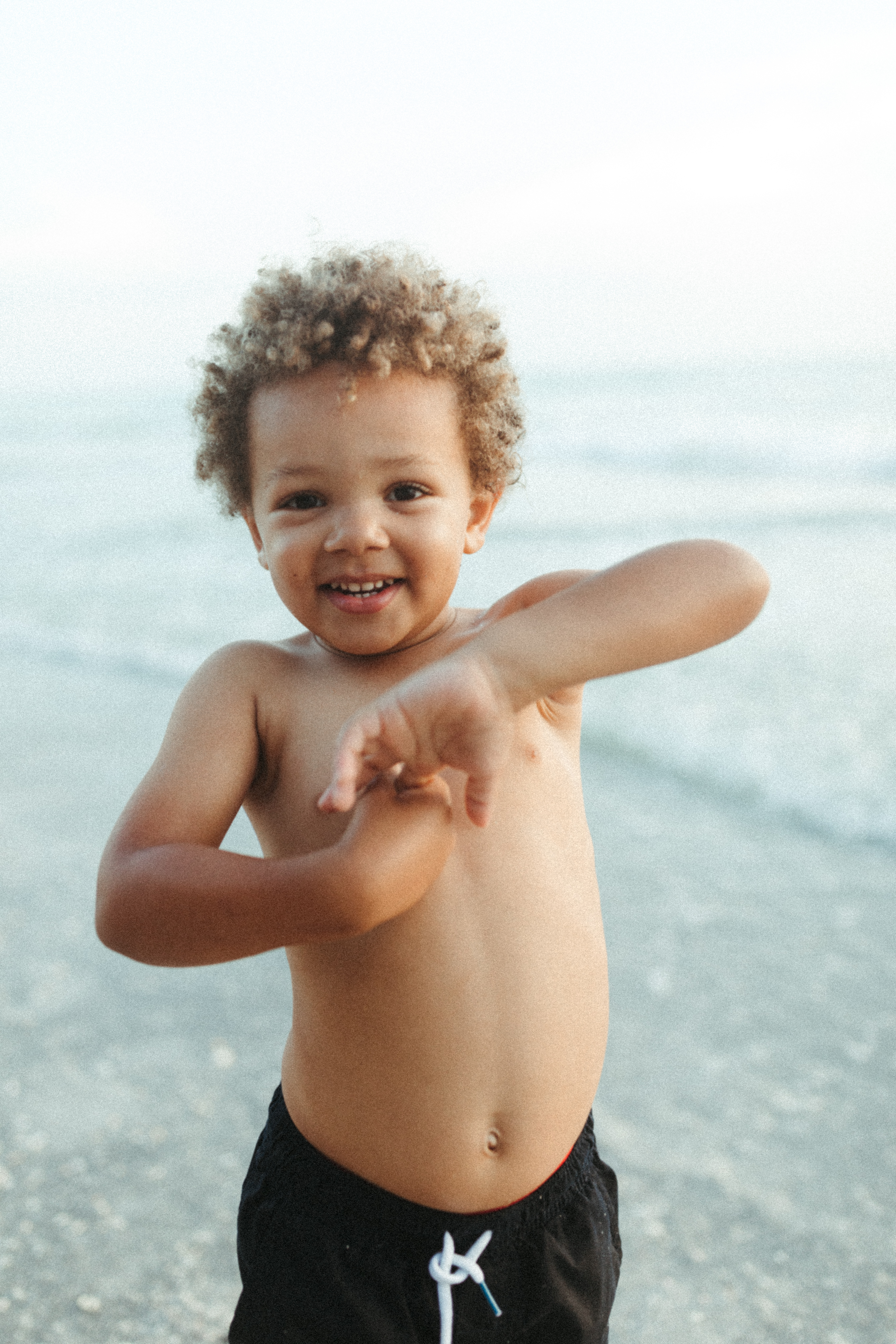 Little boy stands by the ocean in Venice Beach, Florida