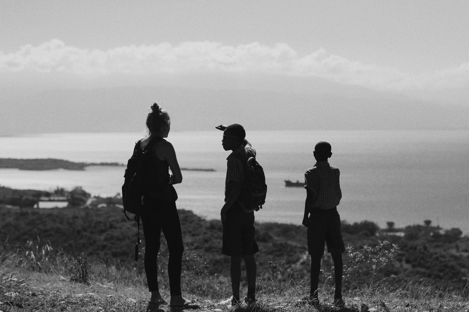 Lauren Neal stands alongside two Haitian boys at school overlooking the Caribbean ocean in Port-au-Prince, Haiti
